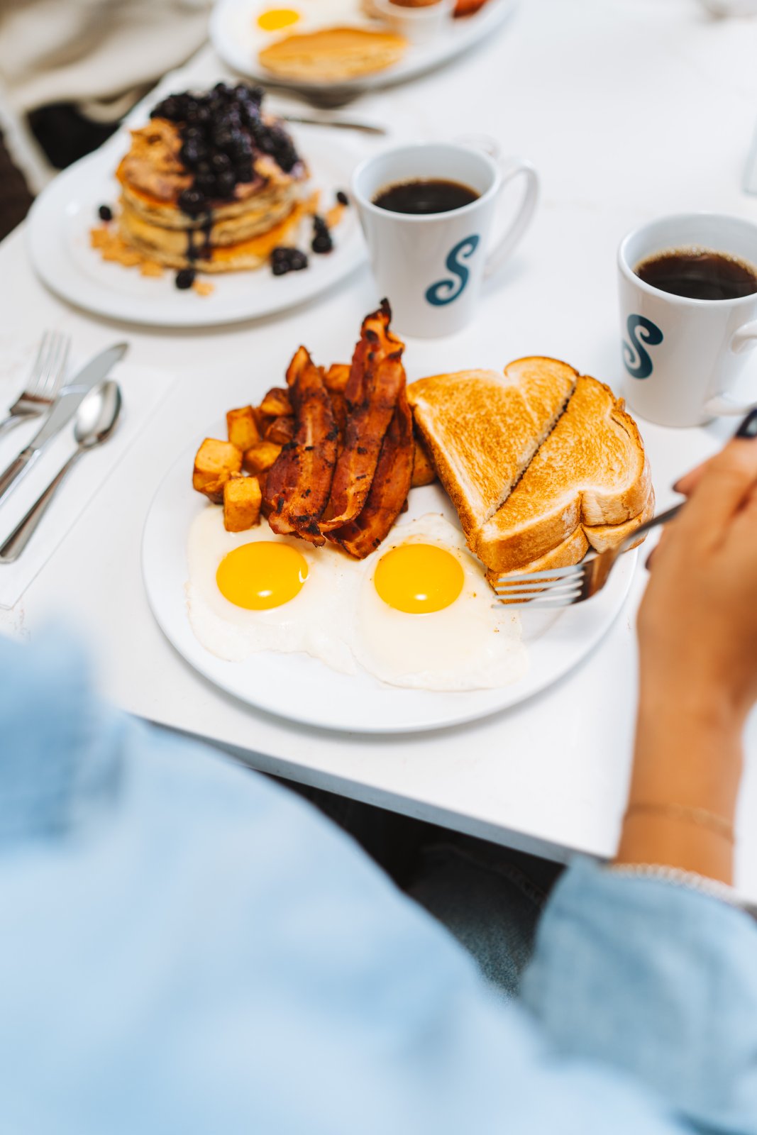 Deux œufs, bacon, pommes de terre et rôties avec café — Suma, Delson